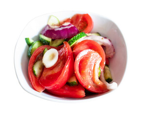 homemade salad from sliced fresh vegetables (oiled tomato, cucumber, onion) in white bowl cut out on white background