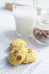 Chocolate chip cookies served with milk on rustic background