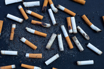Cigarettes buds with ashtray on dark background.