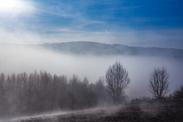 Fototapeta na wymiar Fog falling to the bottom of the mountain valley
