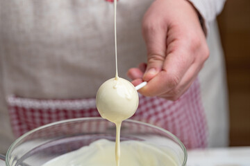 the making of cake pops with a melted chocolate coating