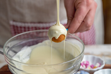 the making of cake pops with a melted chocolate coating