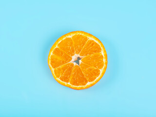Orange tangerine slice on blue background