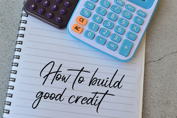 Selective focus of calculators and notebook written with text HOW TO BUILD GOOD CREDIT. Business concept. 