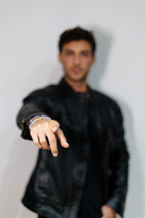 Selective focus on the hand of a man in informal clothes pointing to the front