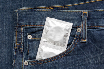 Silver pack condoms are lying in side pocket of jeans. Concept safely sex, prevention from aids.