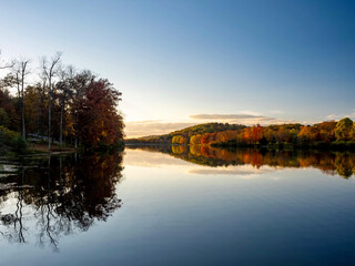 Keystone Lake in Keystone State Park in West Moreland Country in the Laurel Highlands of Pennsylvania in the fall with the foliage tree line reflecting in the water.