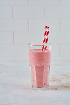Vegetarian healthy smoothie from strawberry with berries on gray or white concrete background. Selective focus. Space for text.