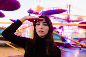 brunette girl with green eyes portrait in an amusement park, fashion photo shoot with vibrant colors and warm tones