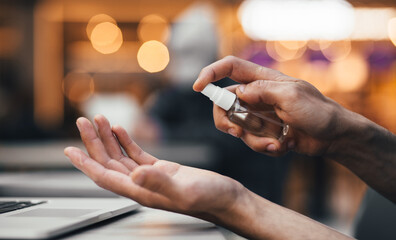 Obraz premium close up. man uses an antiseptic hand spray.