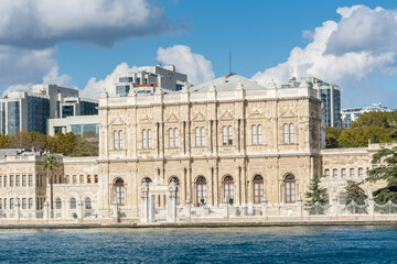 Fototapeta na wymiar Dolmabahce Palace in the Bosphorus strait in Istanbul Turkey from ferry on a sunny day with background of cloudy sky