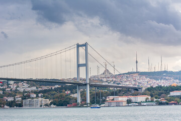 Naklejka premium Bosphorus Bridge with background of Bosphorus strait on a sunny day with background cloudy blue sky and blue sea in Istanbul, Turkey. Blue Turkey concept.