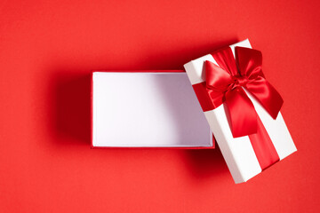 White open gift box with red bow on red background. Valentine day, birthday, Christmas, concept,...