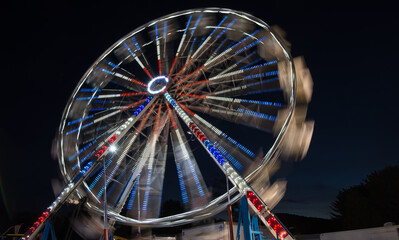 Ferris wheel in blurred motion at night in American flag colors
