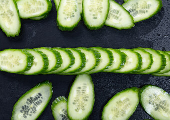 sliced fresh cucumber on a black plate