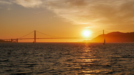 Golden Gate Bridge bei Sonnenuntergang mit der untergehenden Sonne im Hintergrund