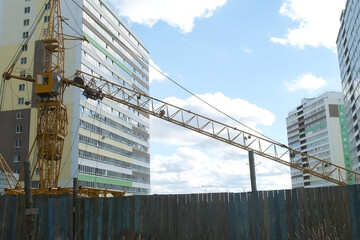 Tower crane on a construction site for lift a load at high-rise building. Construction of...