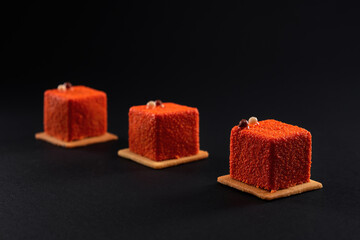 Orange cakes with matte surface isolated on black.