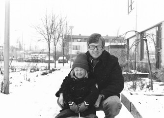 1978 vintage, seventies, retro monochrome portrait of father and daughter in winter snow setting in...