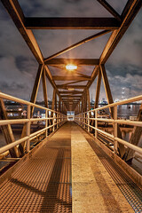 Night scene with Illuminated metal pedestrian bridge at Industrial pier, Port of Antwerp.