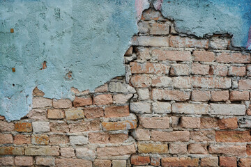 Vintage brick wall with crack blue plaster for texture and background.