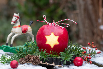 Weihnachtsdekoration mit Apfel mit Sternmotiv und Schaukelpferd