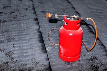 Gas burner on the construction of a family house. Asphalt floor insulation. Construction site....