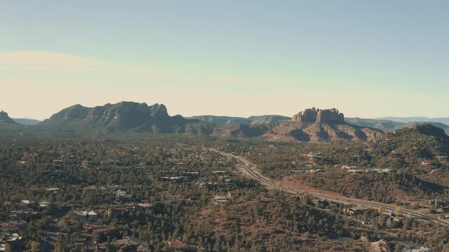 Aerial Drone View of residential areas and roads in Sedona and Oak Creek Canyon in Arizona on a bright and sunny fall day showing unique red rock formations and landscapes 