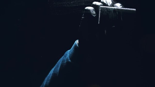 Internal view from inside of the glass a car while being car wash. Washing dishes with a sponge with dishwashing foam gel. Hand holds sponge with detergent or polishing liquid. Polish, or wash dish.