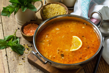 Turkish cuisine. Traditional soup with rice, lentils and mint on a rustic table. Copy space.