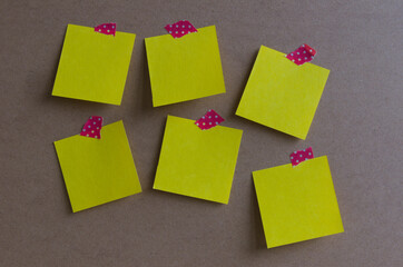 Six yellow square paper attached to a board red white dotted tape