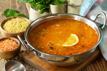 Turkish cuisine. Traditional soup with rice, lentils and mint on a rustic table.