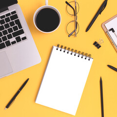 Workspace with laptop and open notebook mockup on a yellow background. Distance education, remote work, online business concept.