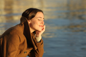 Relaxed woman meditating on the beach in winter