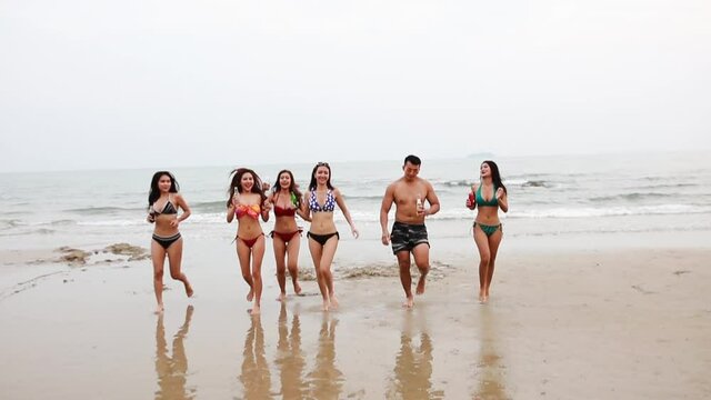 Happy tourism group runing on beach, close friend group run playing on beach 