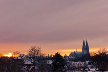The cathedral St. Peter in Regensburg on cold winter morning in December with fresh snow on the roofs and spires