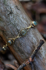 Fototapeta na wymiar brass bracelet with labradorite stone on wooden background