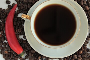 cup of dark bitter coffee with beans and pepper