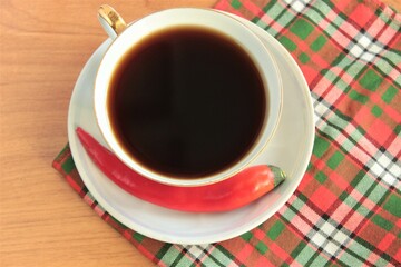 Cup of bitter black coffee and hot pepper