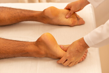 Fototapeta premium Close em mãos de massoterapeuta aplicando massagem em pé de paciente.