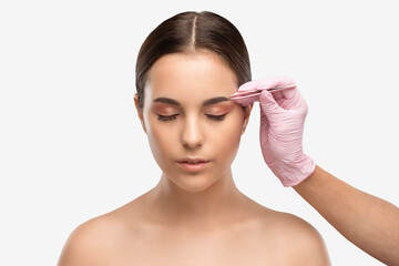 Makeup artist combs  and plucks eyebrows after dyeing in a beauty salon.Professional makeup and cosmetology skin care.