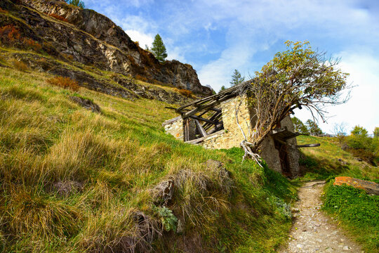 Hiking trail in the beautiful surroundings of Zermatt in Switzerland with old dilapidated mountain hut along the way. 