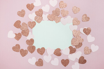 Many sparkling hearts and blank card on pastel pink background. Valentines Day composition with free space for text.