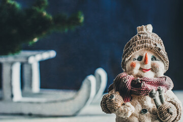 Decorative snowman on the background of winter sledges. Christmas composition