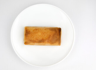 Baked stuffed pancake on a white plate.