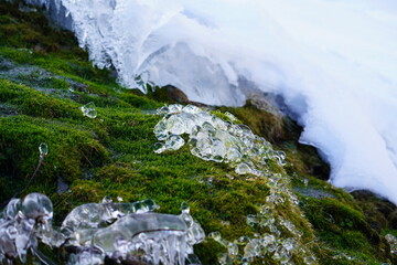 a water source with ice crystals in snow on the mountains in winter