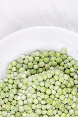 Frozen Green Peas on the white plate