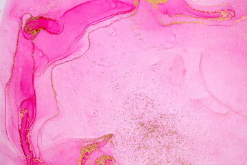 Alcohol ink pink and gold abstract stains background. Drops watercolor transparent texture.