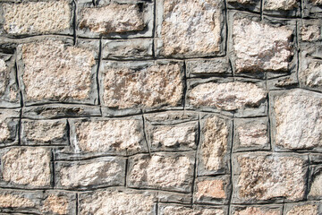 stone wall background. design decorative uneven cracked real stone wall surface with cement