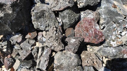 black unusual stone background. dark background from crushed slag, close-up.